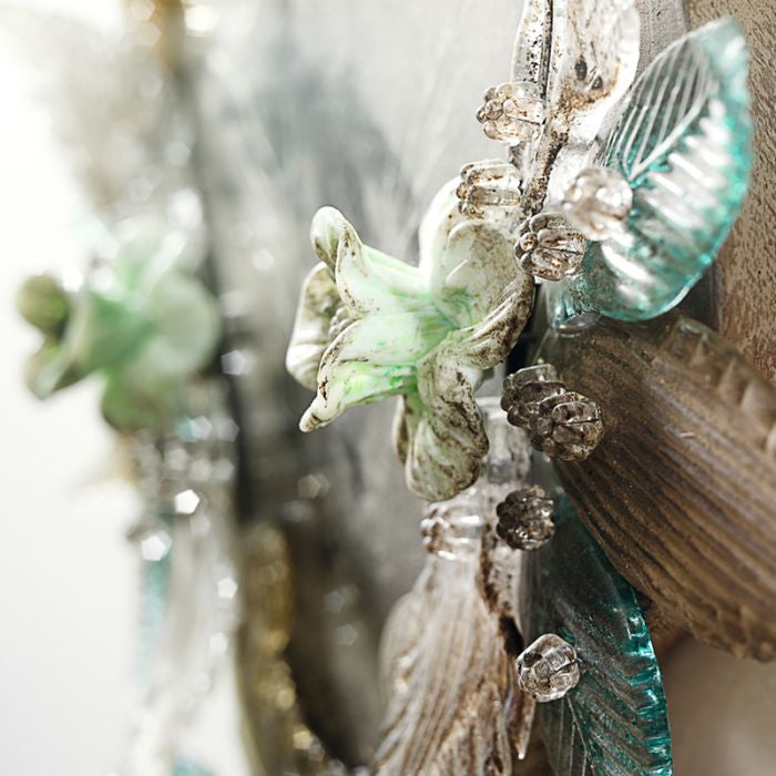 Close-up of decorative glass flowers, leaves and twisted glass edging on a present-day Venetian mirror