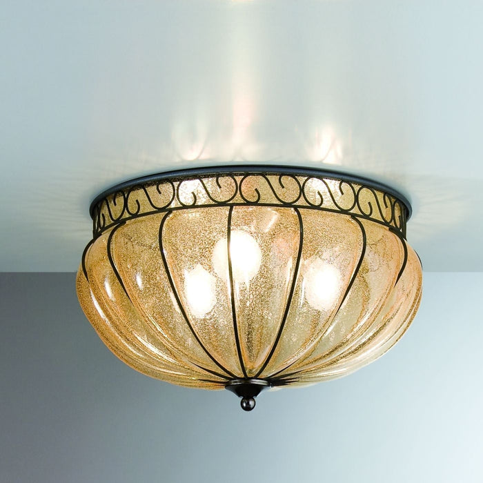 Classic amber hand-blown Venetian glass flush ceiling light with ornate bronze ironwork frame, installed on a hallway ceiling