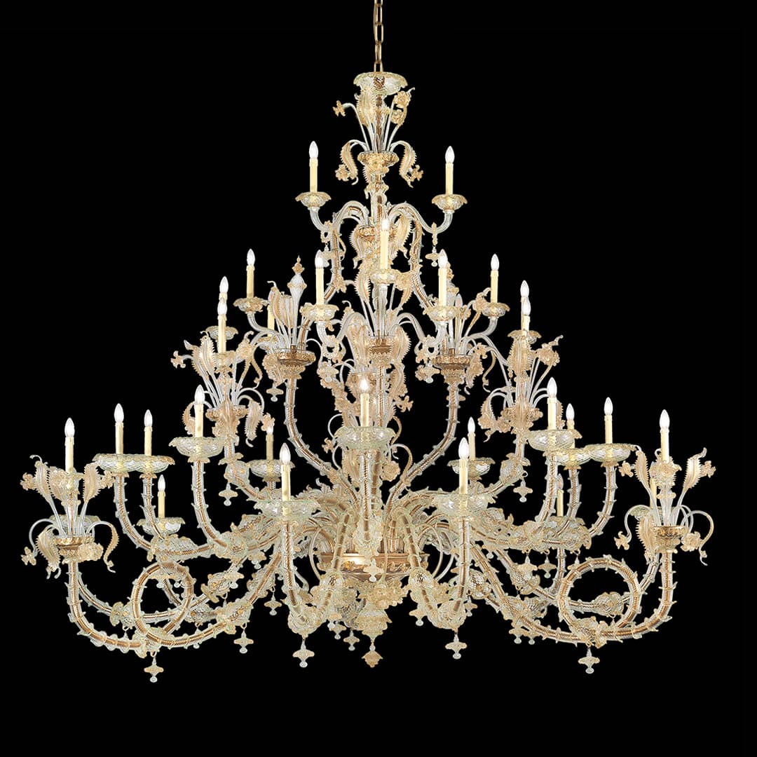 Tiered Rezzonico-style Murano glass chandelier with clear curved arms, gold detailing and decorative glass leaves against a black background