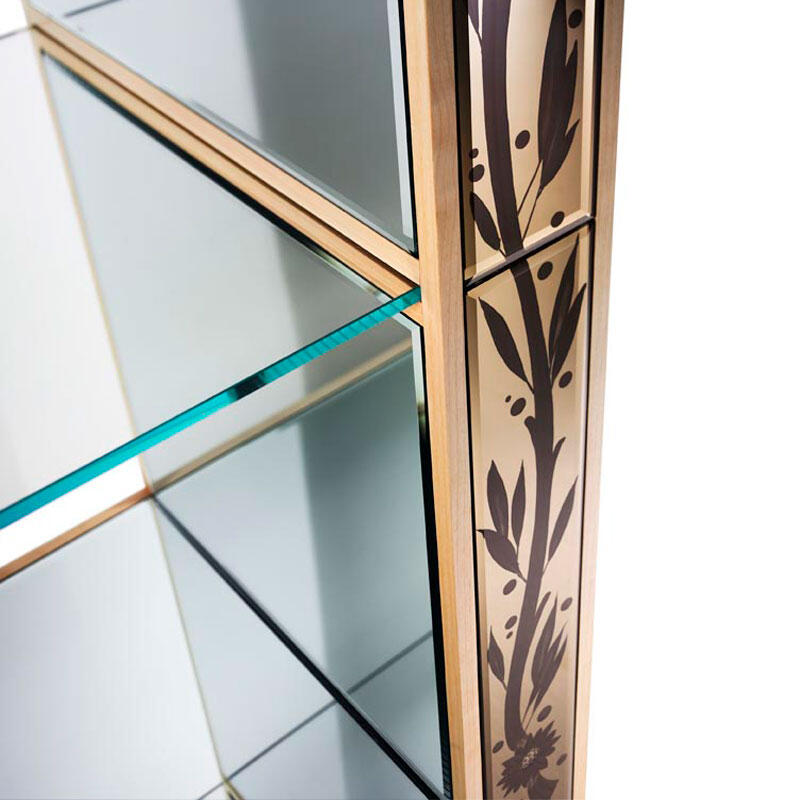Decorative glass shelf with gold frame and leaf pattern on a white background